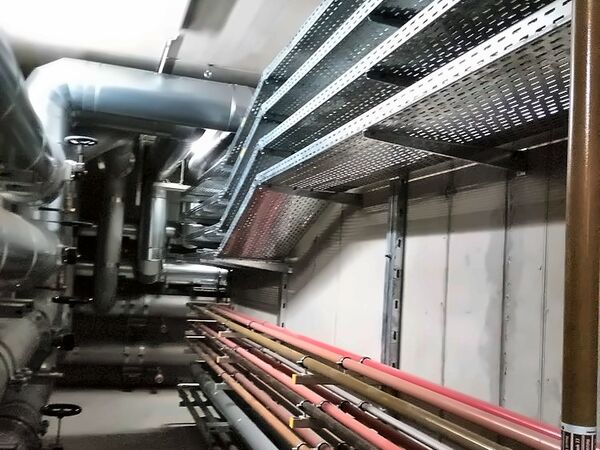 Rurociągi i trasy kablowe w korytarzu technicznym